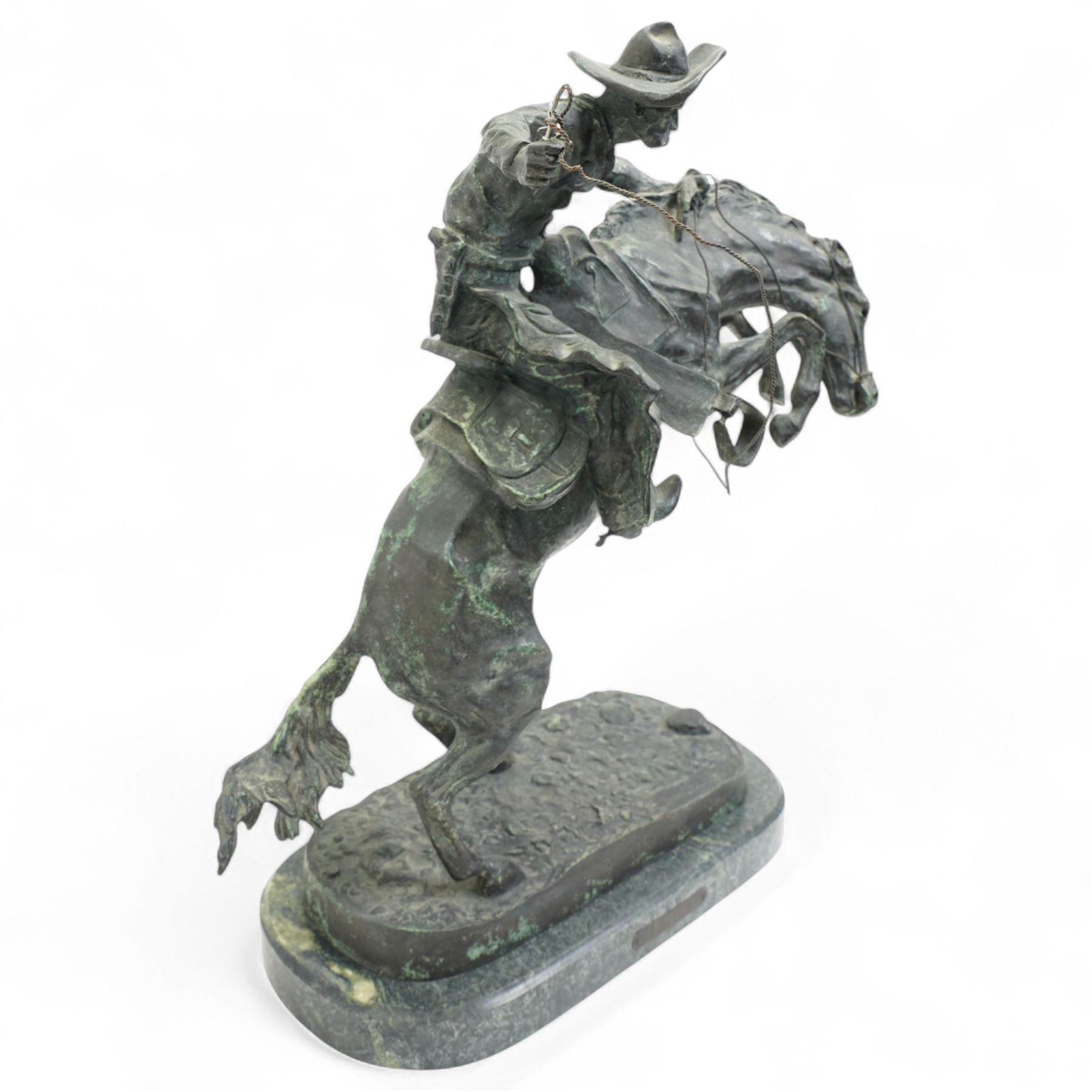 After Frederick Remington (American 1861-1909): 'Bronco Buster', limited edition bronze bearing signature and numbered 7/100, with foundry or ranch mark to horses backside of a triangle within circle, on green marble base, H56cm