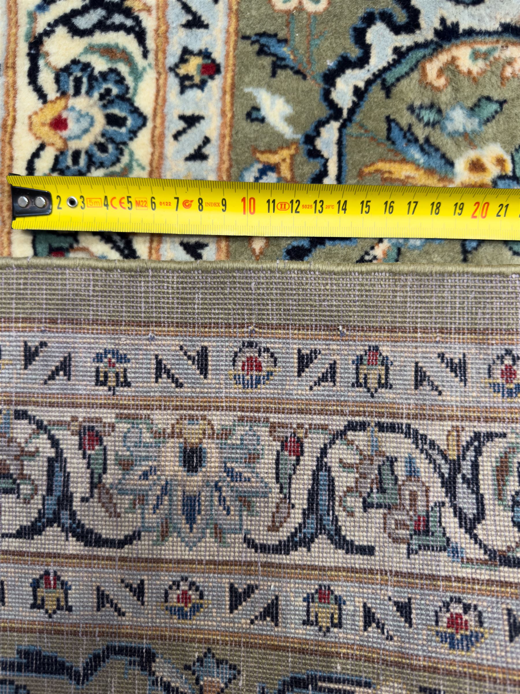 Central Persian Kashan hand-knotted carpet, ivory field with scrolling vines, palmettes, and rosettes around a cusped medallion with pendants and spandrels within a blue ground border of palmettes and flowerheads, 388cm x 300cm