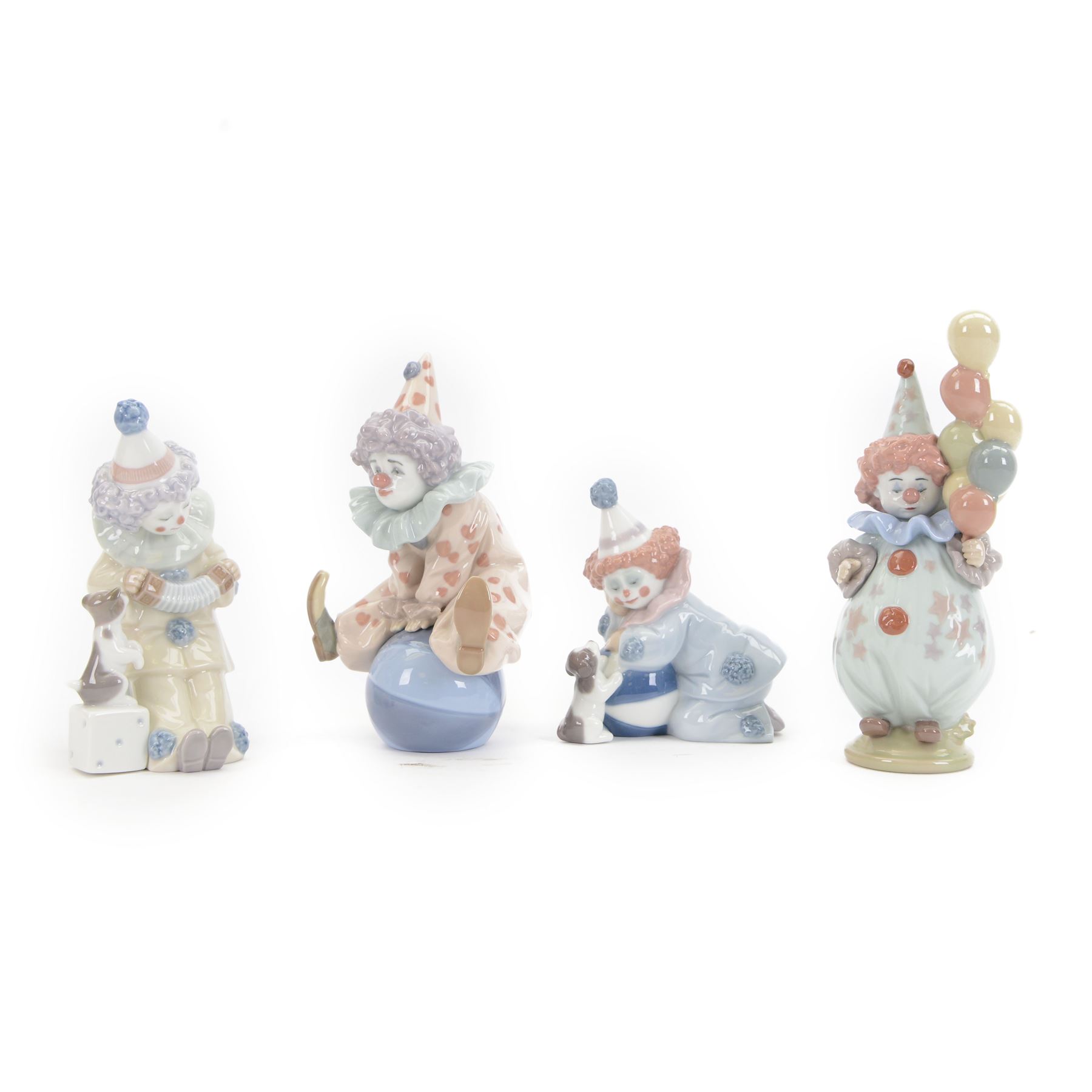 Four Lladro clown figures, comprising Having a Ball 5813, Little Clown 5811, Clown with Puppy 5278 and Pierrot with Concertina 5279
