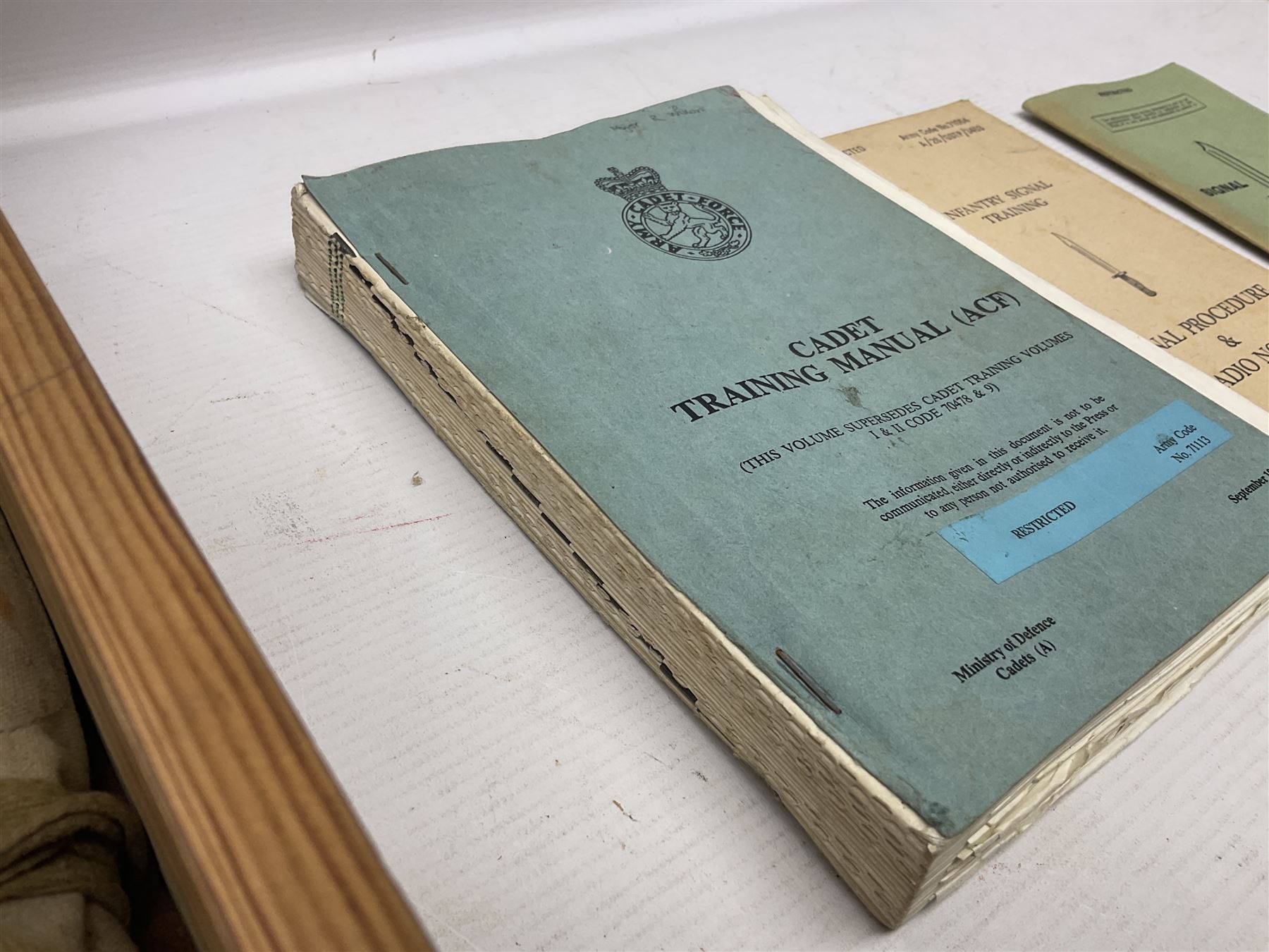 Collection of nineteen British Army booklets 1940s - 1970s including Small Arms Training 1944, various Infantry Training, Cadet Training Manual 1978, Signal Training, Commander's Aide Memoires etc; 1950s blue beret with Yorks Brigade badge; part travelling toilet set in cloth roll; all contained in pine box with webbing straps