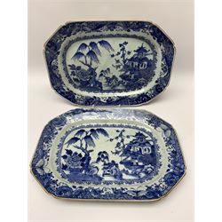 Five late 18th/early 19th century Chinese export blue and white platters, of canted form, comprising two pairs and a further single example, decorated with landscapes set with typical motifs including pagodas, fence, and willow and pine trees, within spearhead and moth and diaper cell borders, first pair W31.5cm, second pair W28.5cm, single example W30cm