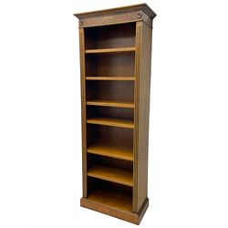 Georgian design walnut open bookcase, projecting cornice over figured banded frieze flanked by roundels, fitted with six adjustable shelves with flanking fluted uprights, on skirted base