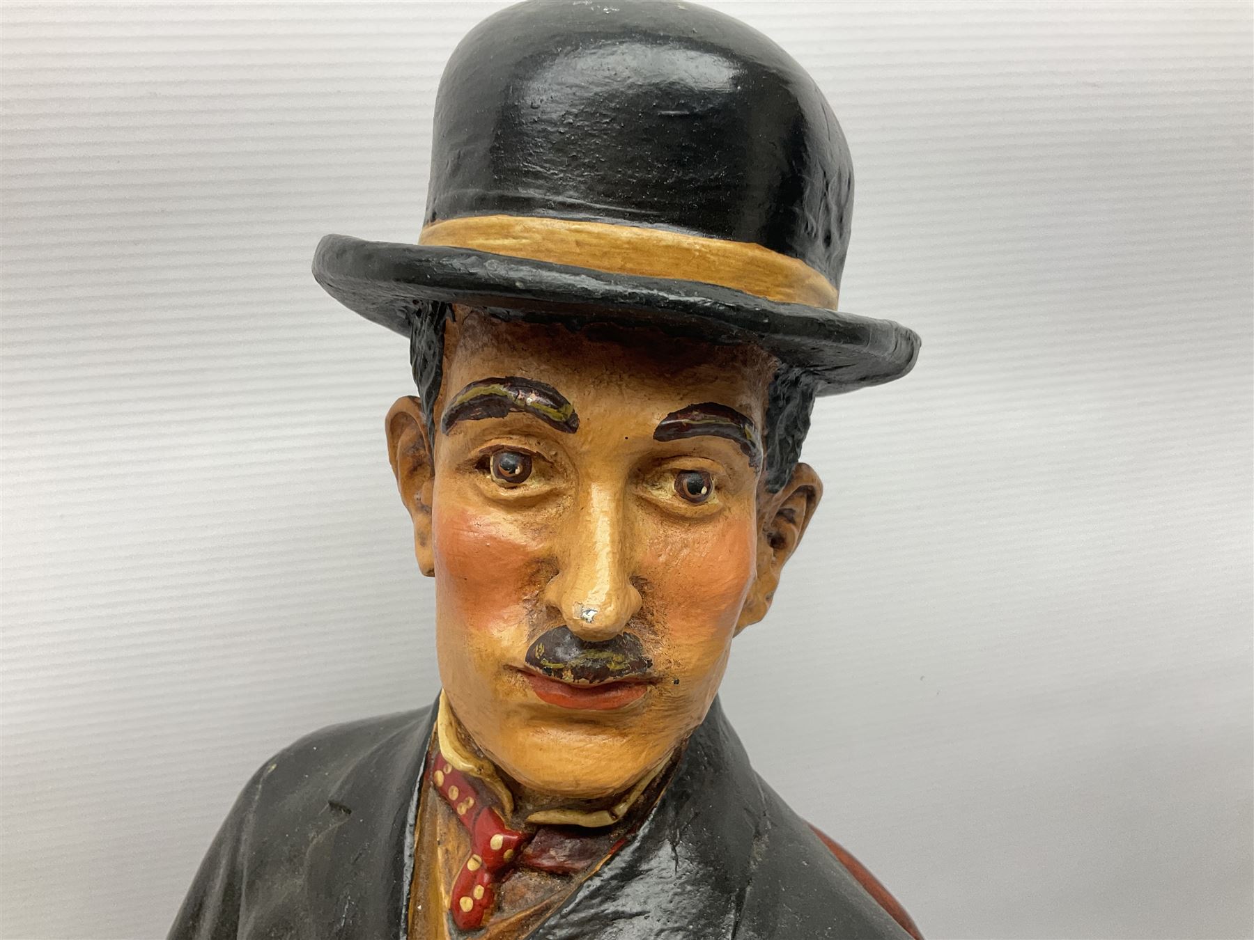Large painted composite figure of Charlie Chaplin, seated upon wooden chair, H54cm