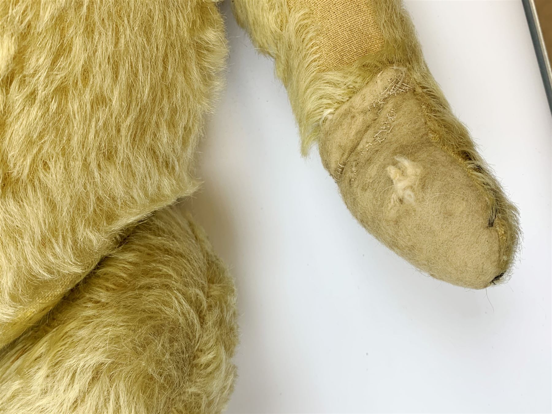 Chad Valley large teddy bear c1930s with wood wool filled blond mohair body, jointed swivel head with glass eyes, shaved muzzle with vertically stitched nose and mouth and jointed limbs H21