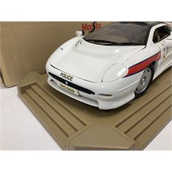 Two Maisto 1:12 scale Jaguar XJ220 scale cars comprising 1992 ‘Concept Car’ West Midlands Police car and 1994 ‘Jag 999’ Thames Valley Police Traffic Car, both on plinths with original boxes and certificates of authenticity 