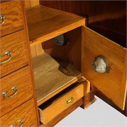 Edwardian mahogany triple combination wardrobe, the moulded cornice above a central panel door inlaid with foliate detail, flanked by full length mirrored doors, the interior fitted with hanging compartments and a central bank of two short and three long drawers, raised on a shaped bracket feet