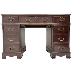 Georgian design mahogany twin pedestal desk, the top with inset red oxblood leather writing surface, fitted with nine cock-beaded and graduating drawers