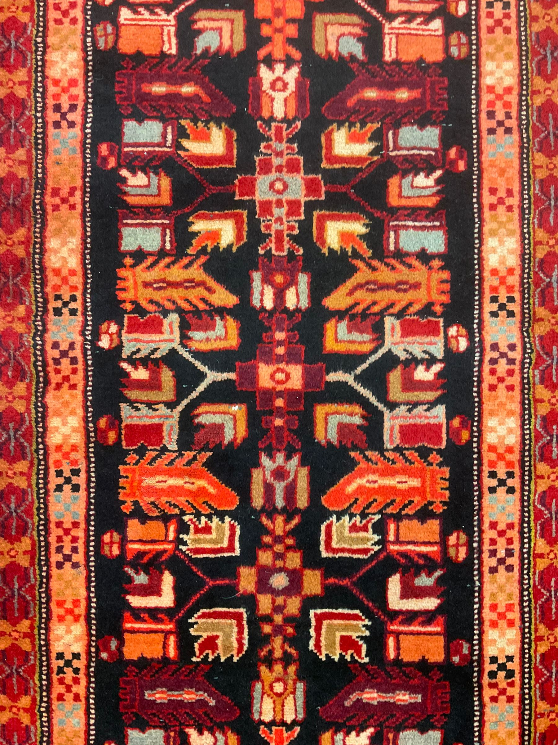 North West Persian Heriz runner, dark indigo ground field decorated with Herati motifs, peach and red borders with geometric design 