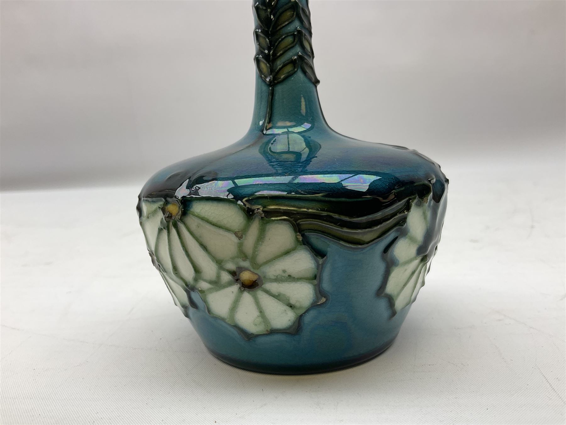 Minton Secessionist vase, with tube-lined stylised flower decoration, upon a blue ground, with printed mark to base 'Minton Ltd, No. 32', H13cm
