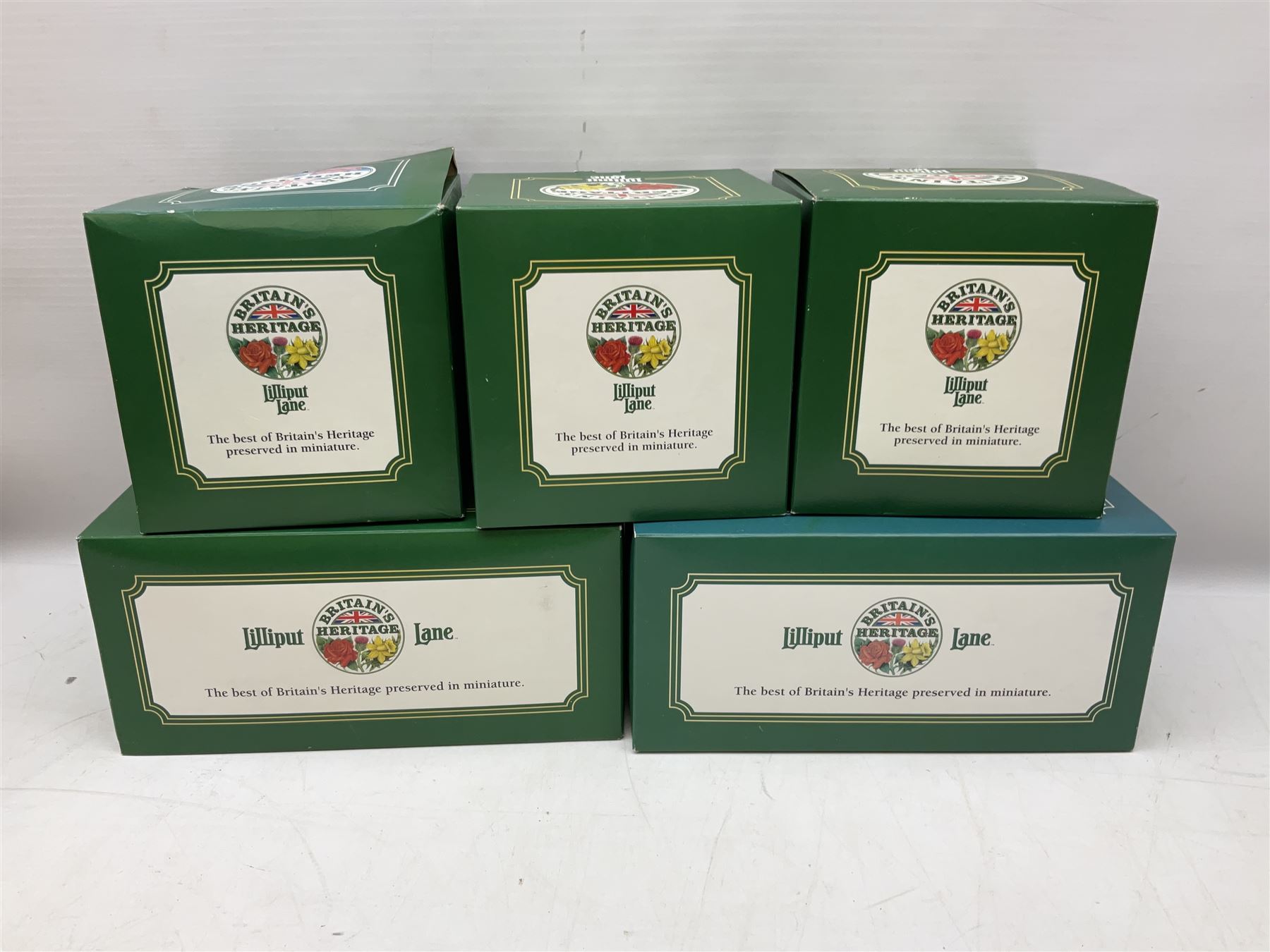 Five Lilliput Lane models from the 'Britain's Heritage' collection, comprising The Royal Albert Hall, Windsor Castle Round Tower, Eros and Nelson's Column and another snowed, all boxed