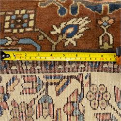 North West Persian Tafresh hand-knotted rug, pale apricot field with central stepped medallion enclosing stylized floral and angular motifs framed by indigo spandrels and multiple stylized floral borders, cotton fringe ends 