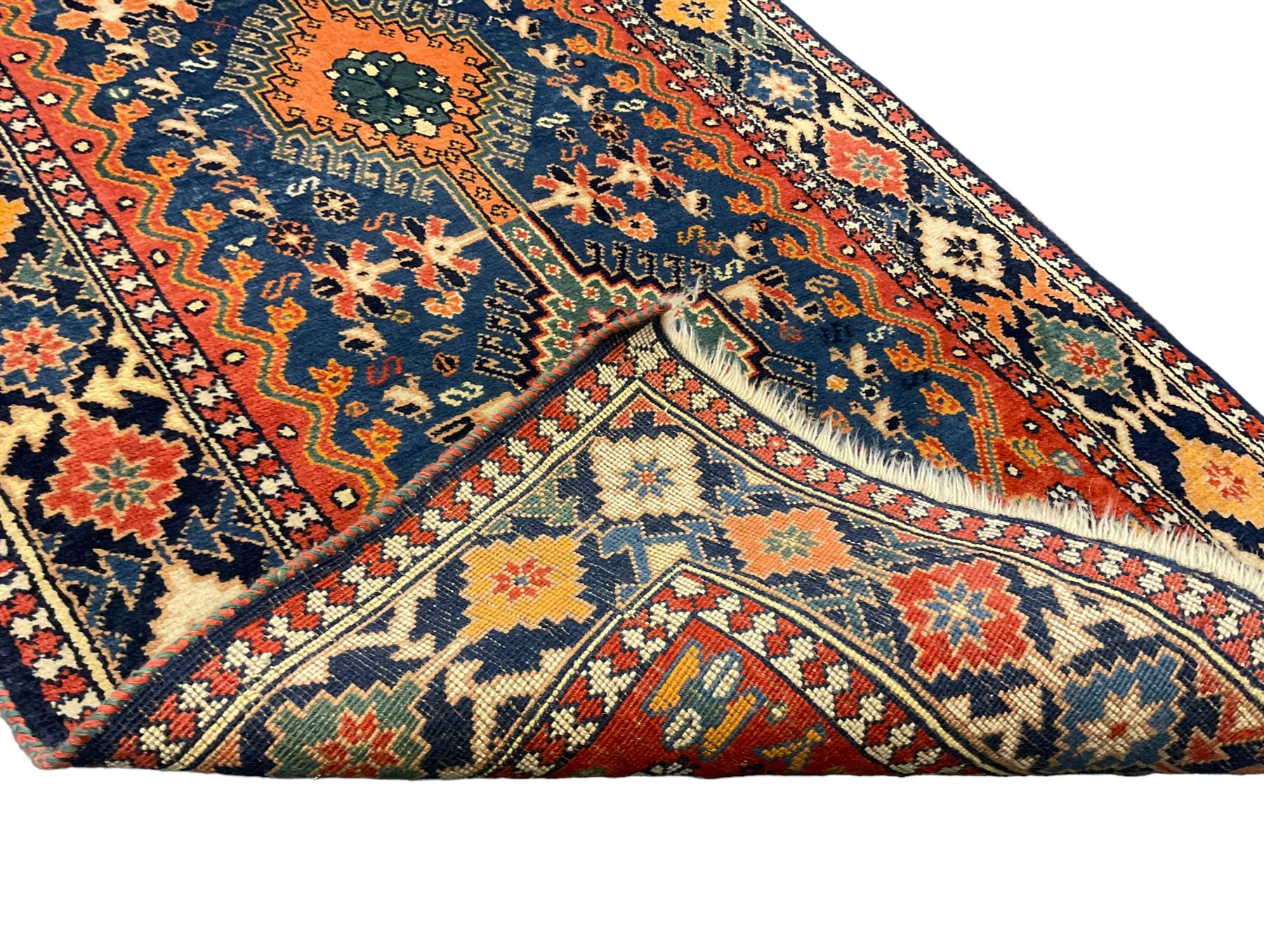 Persian blue ground rug, field decorated with four pole medallions with surrounding repeating bird motifs, coral spandrels with flowerheads, guarded border decorated with repeating geometric lozenges