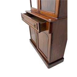Victorian mahogany bookcase on cupboard, fitted with two glazed doors above single drawer and two cupboards, rounded corners