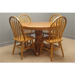  Oak circular dining table on turned column with four splayed supports (D107cm, H76cm), and four hoop back dining chairs  