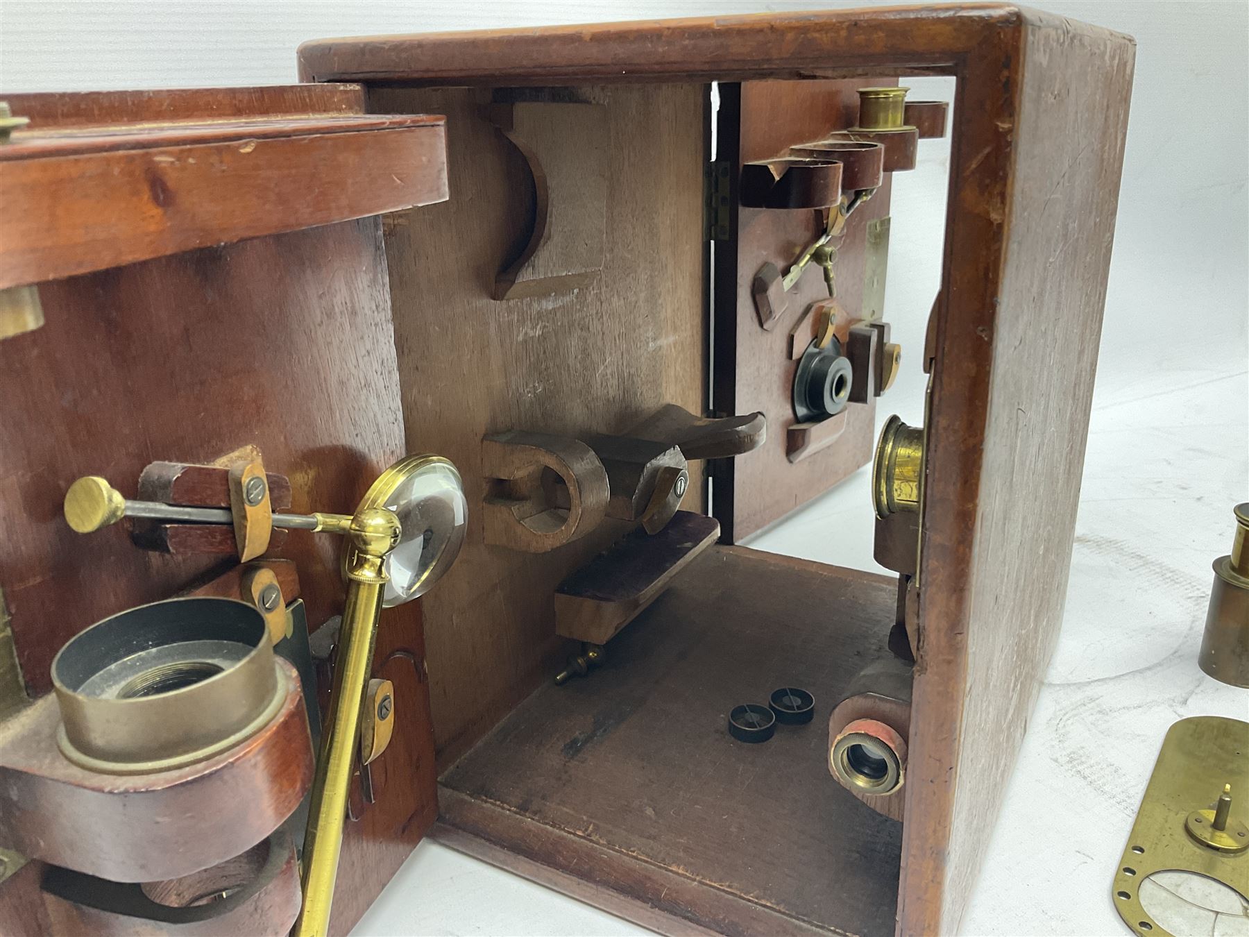 Mid 19th century brass monocular microscope by Andrew Ross, London No.180, with pitchfork base, rack and pinion focusing, revolving bed and swivelling barrel, with accessories, housed in a mahogany case with recessed carry handle and lockable doors