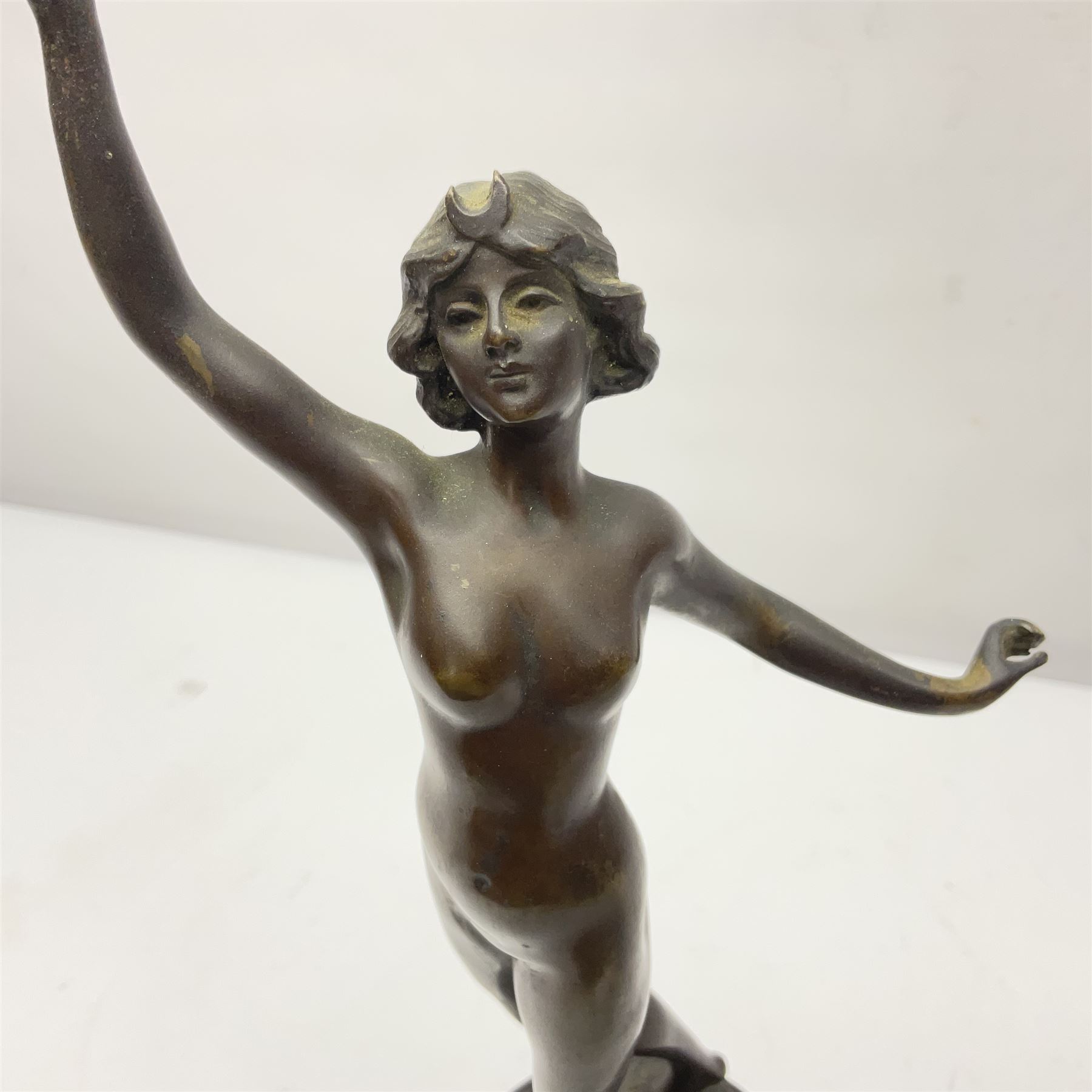 Bronze figure modelled as a nude woman with one arm raised a crescent moon upon her forehead, raised upon a circular stepped plinth, H36cm