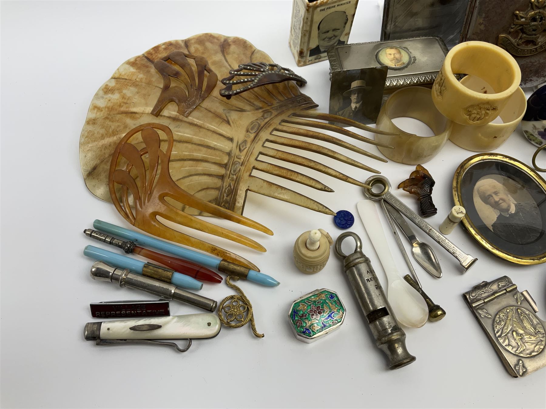 A group of assorted collectables, to include small oval purple guilloche enamel frame, WWII matchbox holder depicting Winston Churchill, Halcyon Days enamel box, Ronson table lighter, ebonised glove stretchers, ivory napkin ring, mother of pearl handled button hook, engine turned cigarette case, etc. 