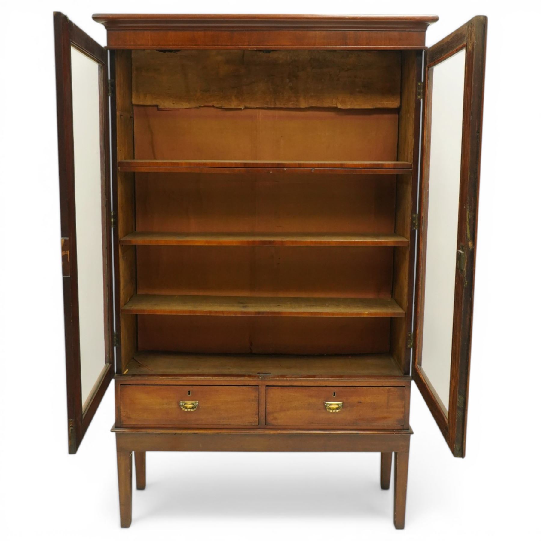 19th century mahogany enclosed bookcase on stand, projecting cornice and banded frieze over two glazed doors enclosing four adjustable shelves, fitted with two drawers to base, on square tapering supports