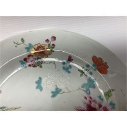 Three 18th century Chinese Famille Rose plates, the first example enamelled with blossoming peonies, rockwork and fence, the other two examples of similar design, decorated with blossoming peonies and sprigs within shaped inner borders, each approximately D23cm