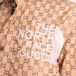 Gucci x The North Face – monogram hooded puffer jacket, beige and ebony GG monogram fabric with embroidered Gucci x The North Face logos to the chest and interior collar, detachable/adjustable hood, zip fastening with silver tone press-studs, flap pockets and vivid orange lining, size S