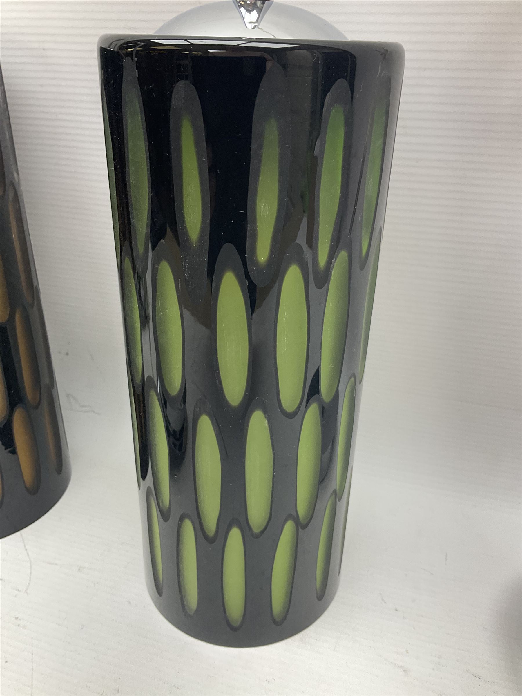 Three contemporary glass pendant lights, the black glass glass cut away revealing green and brown beneath, H24cm