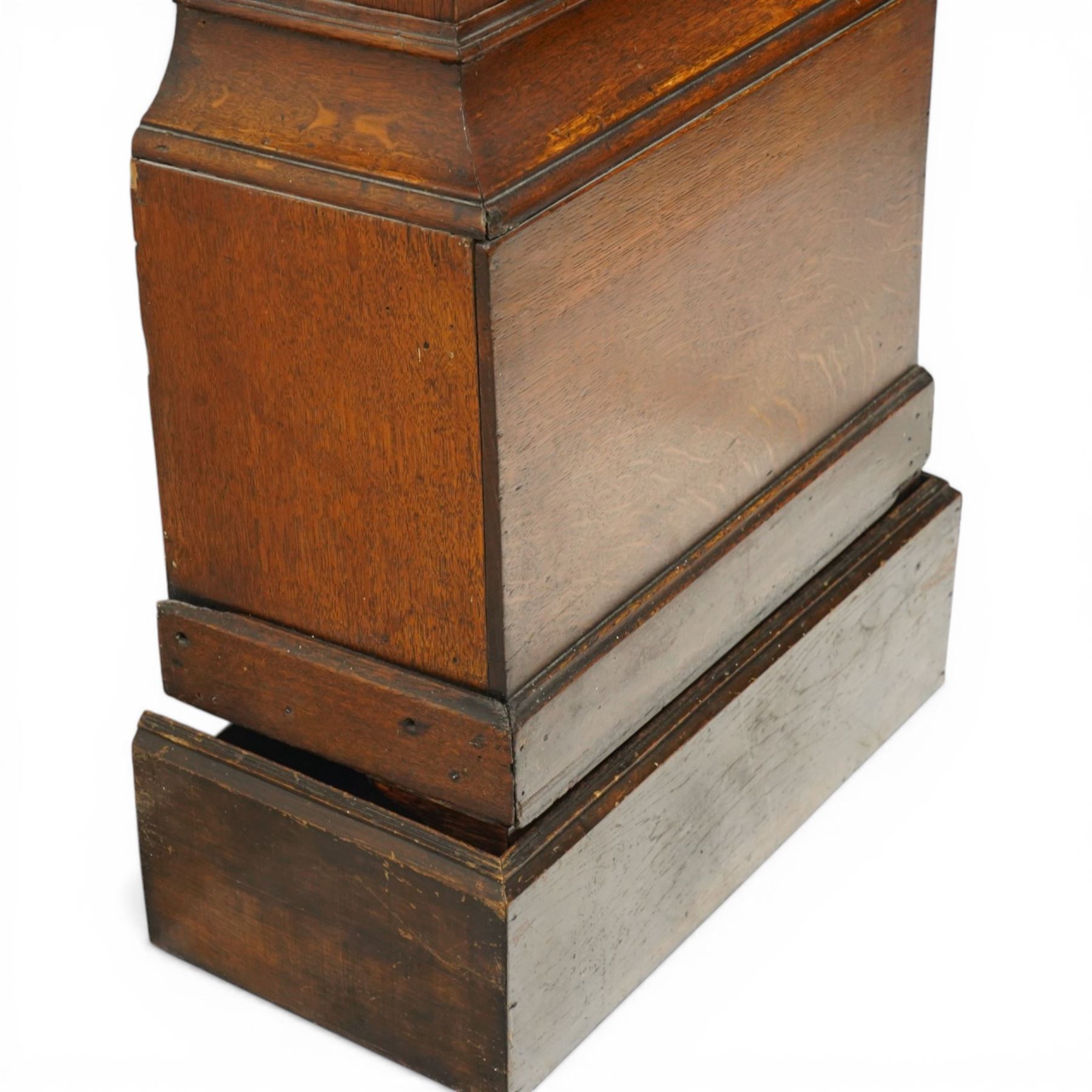 18th century oak eight-day longcase clock,  signed James Smyth, Saxmundham, the arched hood with brass ball and eagle finials, moulded arch pediment over turned columns, brass dial with silvered Roman chapter ring, Arabic minute track, matted centre with subsidiary seconds dial and calendar aperture, engraved boss to arch, the trunk with arched panel door, on stepped plinth base, with two weights and pendulum