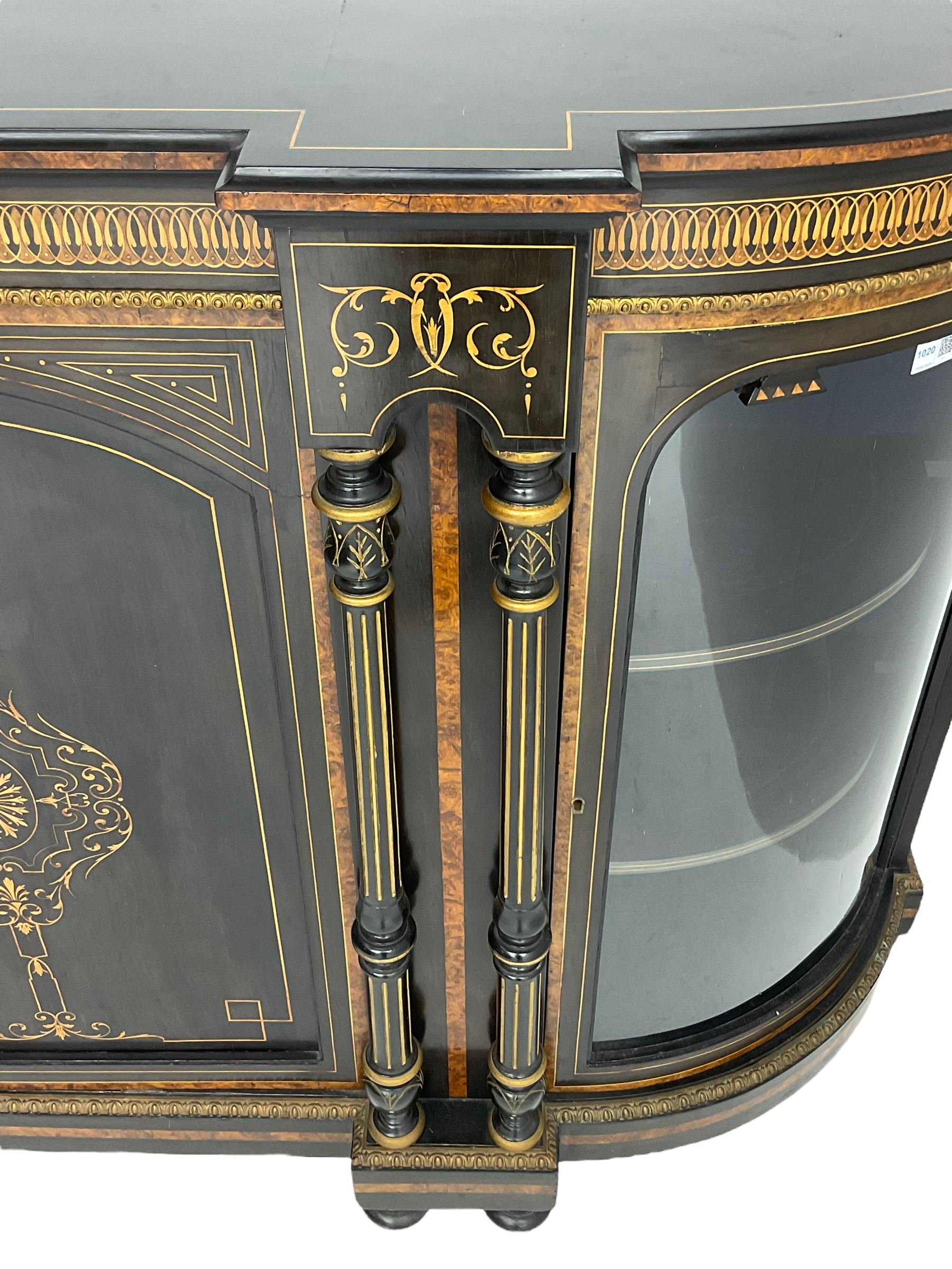 Victorian ebonised and inlaid credenza, break-front with curved ends, the front fitted with two curved glazed doors and central panelled door, inlaid with scrolling foliate and star motifs, quadruple turned and fluted pilasters to front, gilt egg and dart moulded edge on plinth base with figured walnut band, on turned feet