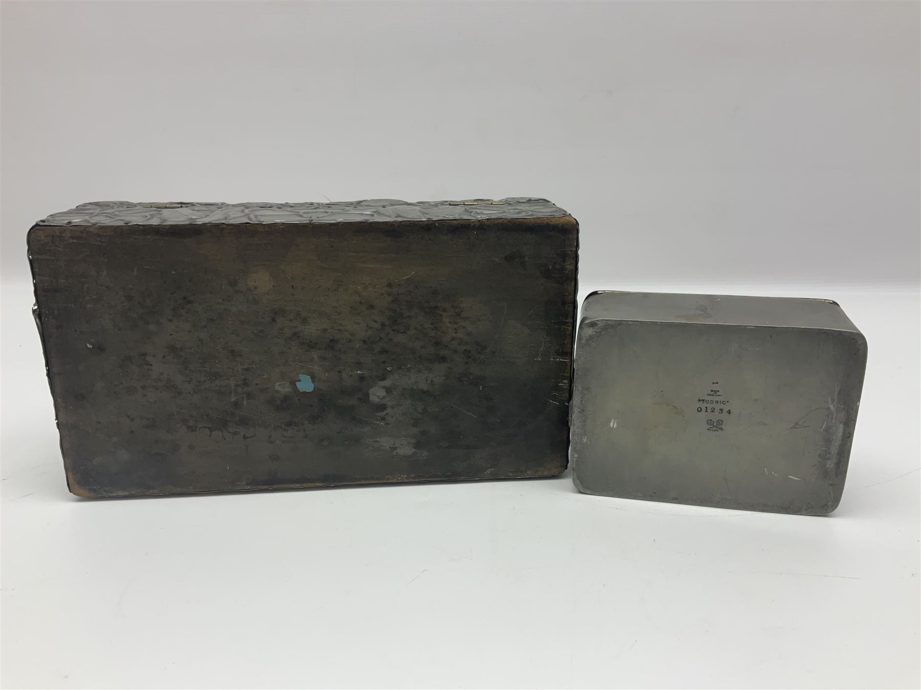 Liberty & Co Tudric pewter cigarette box, of plain rectangular form, with planished decoration to the slightly domed cover, opening to reveal a softwood interior, stamped Made in England 01234 Tudric Solkets beneath, together with another cigarette box, with applied pewter panels repousse decorated throughout with flower heads and leaves, with compartmentalised softwood interior, largest H5.5cm, W23cm