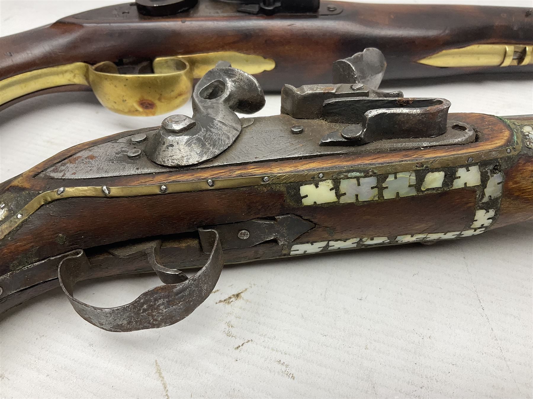 Modern non-firing reproduction Tower flintlock pistol marked with crowned GR and Tower to the lock, brass skull crusher butt and fittings L40cm overall; another Indian/Moorish reproduction flintlock pistol with mother-of-pearl inlay; and a modern die-cast replica Colt style revolver (3)