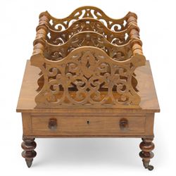 Victorian walnut Canterbury, scroll pierced divisions with turned carrying handles above a frieze drawer with knob handles, raised on turned legs terminating in brass castors