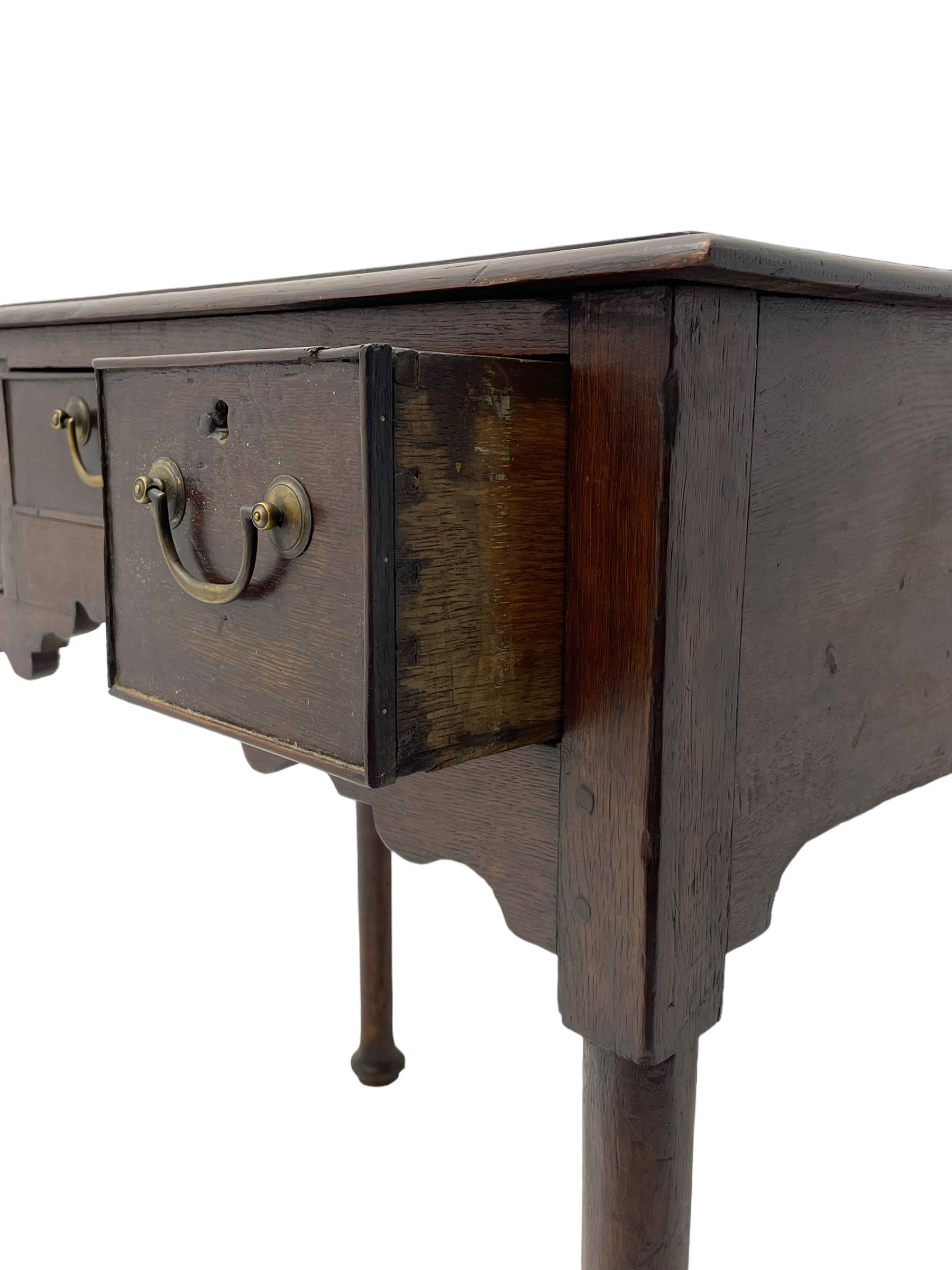 18th century oak low-boy, ovolo-moulded rectangular top over three cock-beaded drawers, circular brass handle plates and D-shaped handles, shaped and stepped arched apron, on cabriole supports 