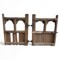 Pair of 19th century weathered wooden ecclesiastical church gates, the cresting rail over four pierced arches with slatted lower section, fitted with heavy cast iron hinges, latch and fittings