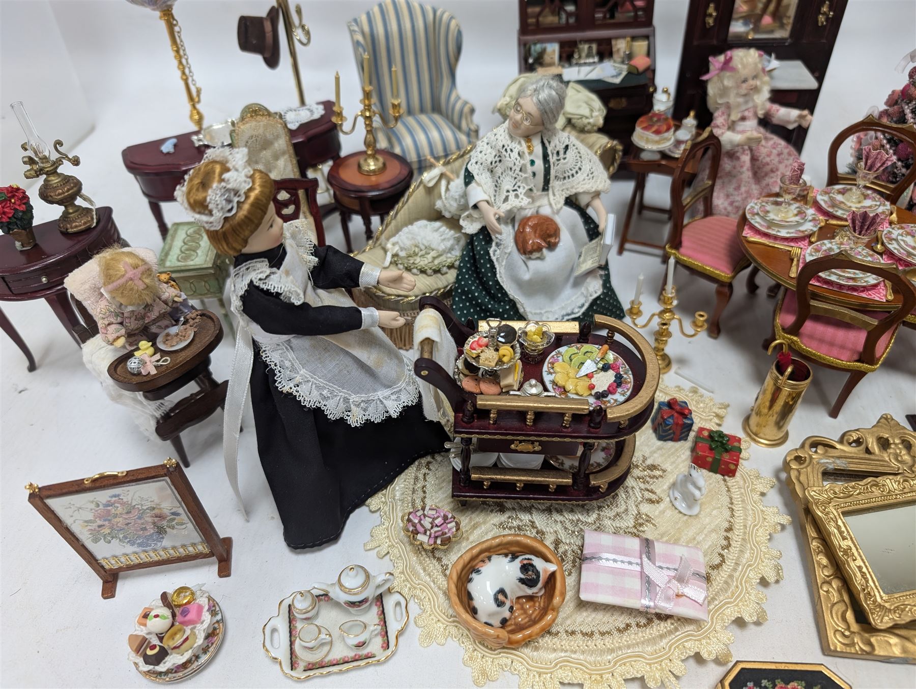 Dolls house living room and ding room furniture, including sofa, chair, long case clock, Christmas trees, fireplace, dresser, chairs, tables, mirrors, seven figures and a collection of predominantly Christmas themed decorations, food, etc