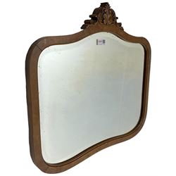 Victorian beech and birdseye maple veneered shaped wall mirror, the pediment carved with foliate C-scrolls and central leaf motif, bevelled glass plate 