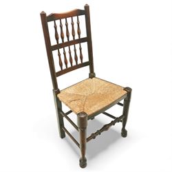 20th century set of five spindle-back dining chairs, with shaped top rails above turned spindle splats, rush seats, turned forelegs united by stretchers