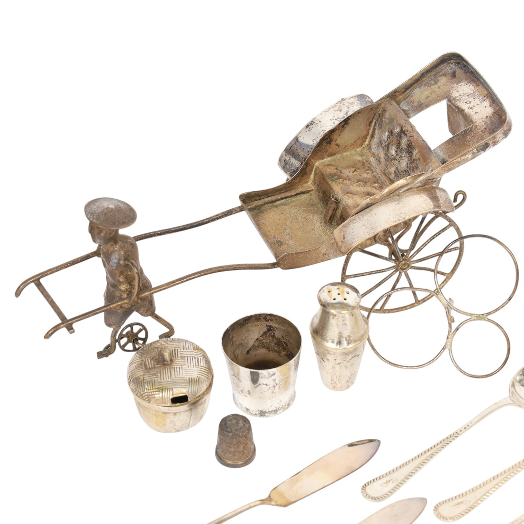 Silver cutlery comprising three teaspoons and two butter knives, a silver handled hook and a silver plated Chinese rickshaw cruet