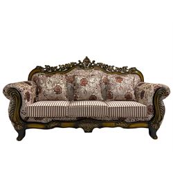 Italian Baroque design three seat sofa, hardwood framed, the cresting rail carved and pierced with c-scrolls and flower heads, scrolled arms, upholstered in floral patterned and striped fabric, with scatter cushions 