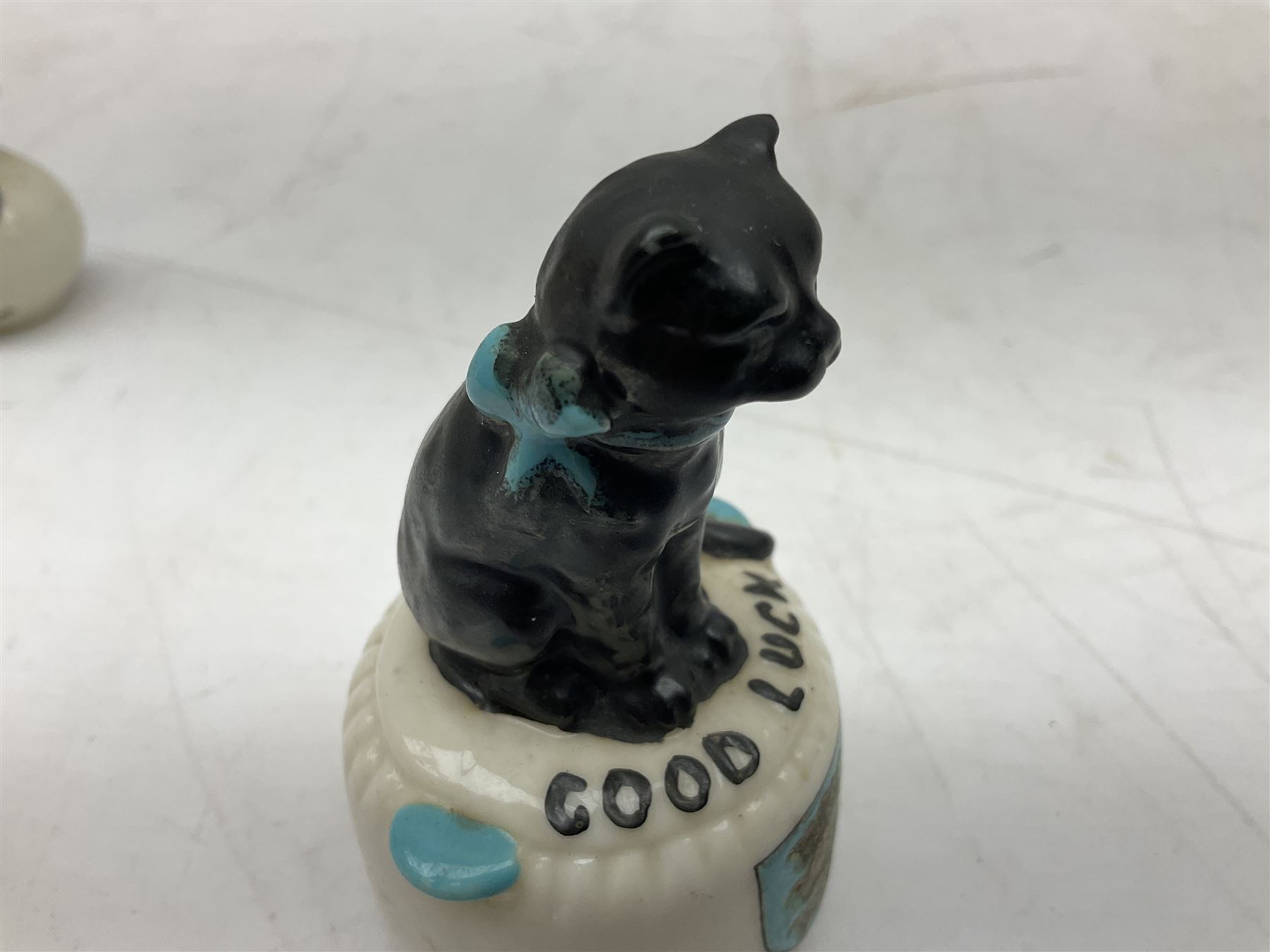 Five crested ware Good Luck black cats, comprising two Willow Art examples, two Arcadian examples and one Carlton China, to include Bridlington, Hull, Filey, etc, tallest H9cm