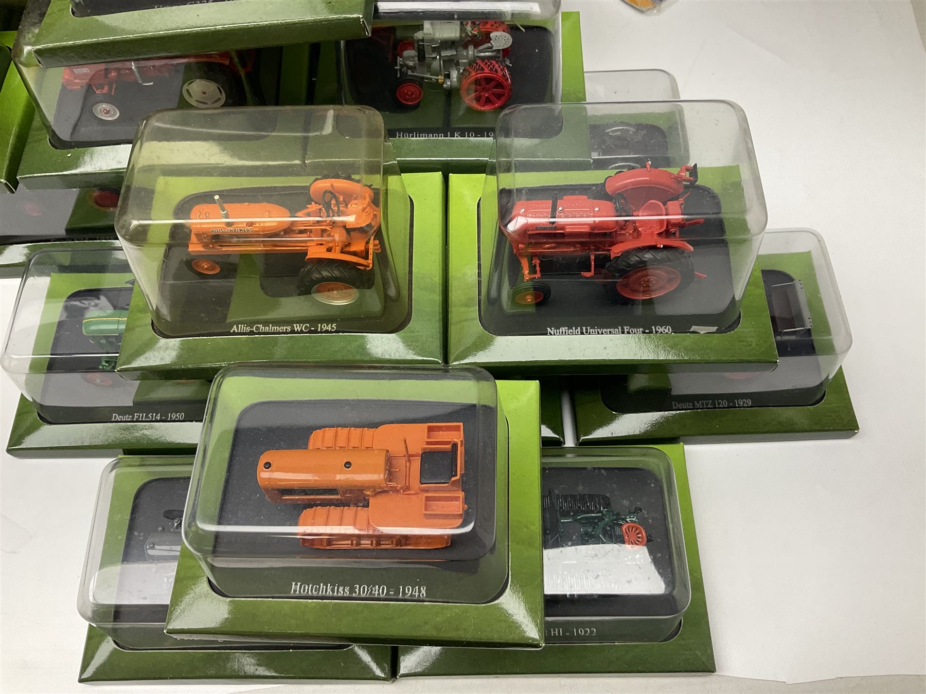 Eighteen issues of Tractors and The World of Farming magazine, together with sixty diecast tractors, all in original packaging, in three boxes 