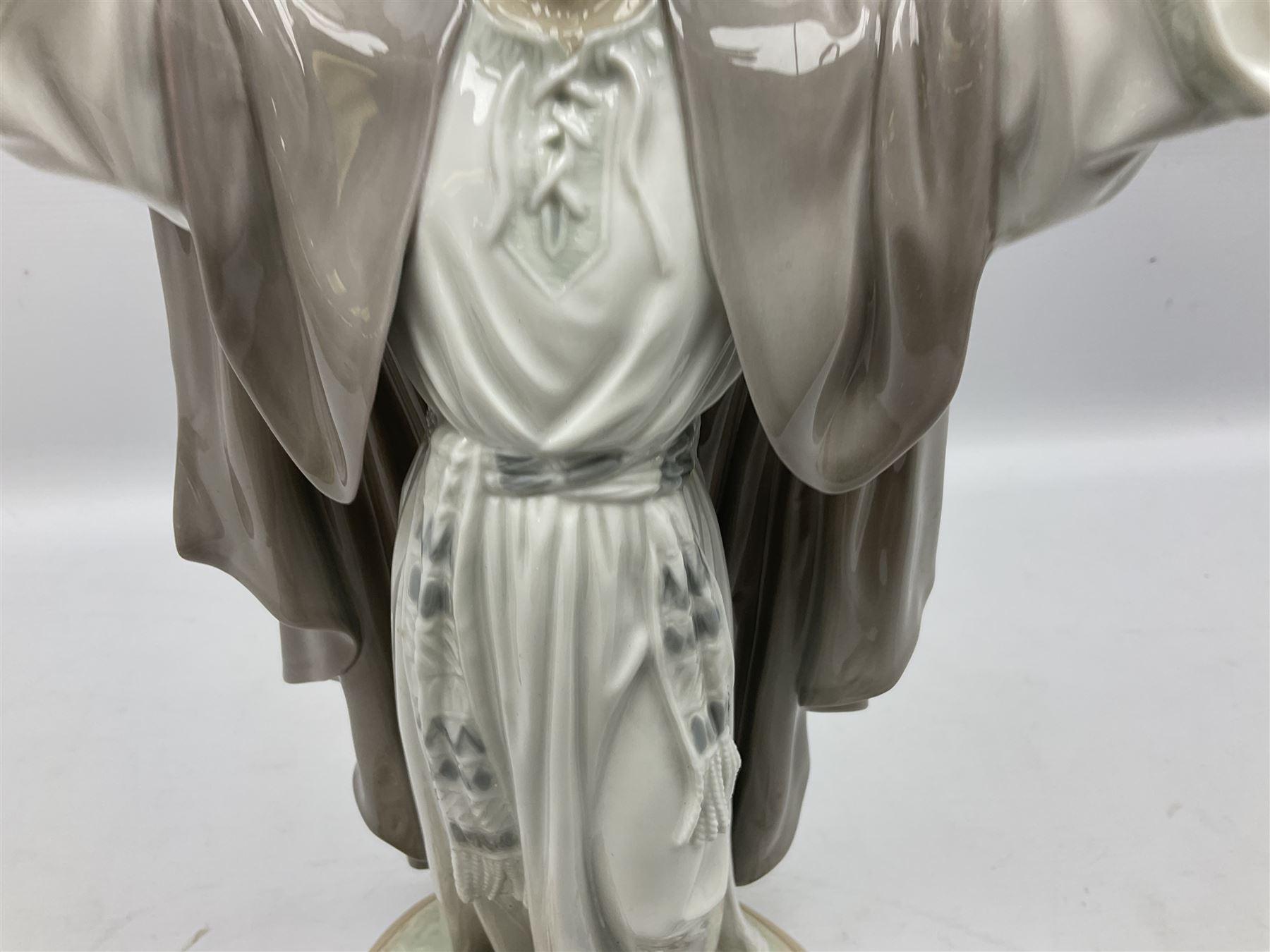 Lladro figure, The Loaves and Fishes, modelled as Jesus Christ with arms raised standing beside a basket of loaves and a basket of fish, sculpted by Salvador Furió, with original box, no 5896, year issued 1992, year retired 1997, H35cm