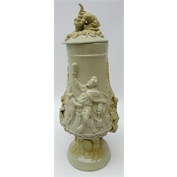  19th/ early 20th century Continental salt glaze/ stoneware footed vase and cover, decorated in relief with Bacchanal and Toping scenes with applied hops and barley & figures drinking (a/f) H40cm   