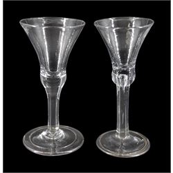 Two 18th century drinking glasses, the bell shaped bowls upon plain stems, one with internal tear, and folded conical feet, tallest H17.5cm
