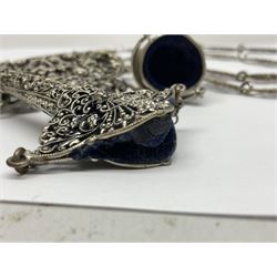 19th century continental silver plated chatelaine, the main body flanked with winged mythical beasts and central soldier slaying a dragon supporting three suspended items to include velvet lined small basket and long clasped filigree chain, together with a thimble