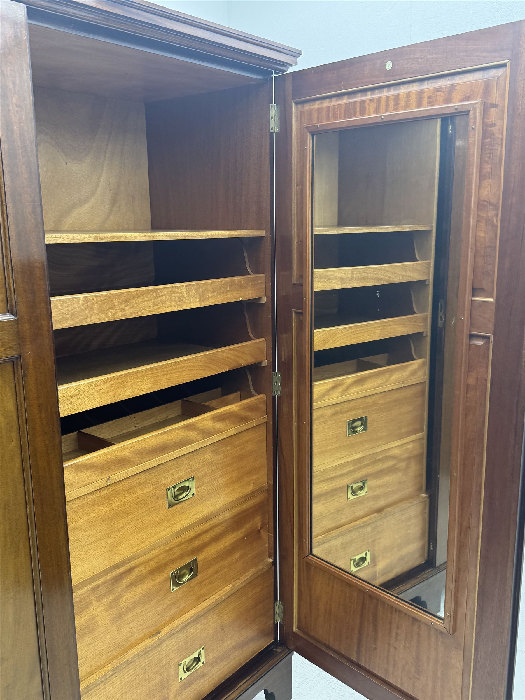 Wylie & Lochhead, Glasgow - early 20th century mahogany and satinwood double wardrobe, projecting cornice over panelled doors, interior fitted with mirrored door, shelves, drawers, hooks and hanging rail, raised on bracket supports with ceramic castors