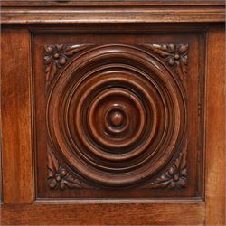 Late 19th century French walnut double bedstead, the panelled headboard with curling foliage carved frieze over concentric turned roundels and faceted mounts, lion mask carved rails with applied panelled mounts, matching footboard with lower carved lion mask 