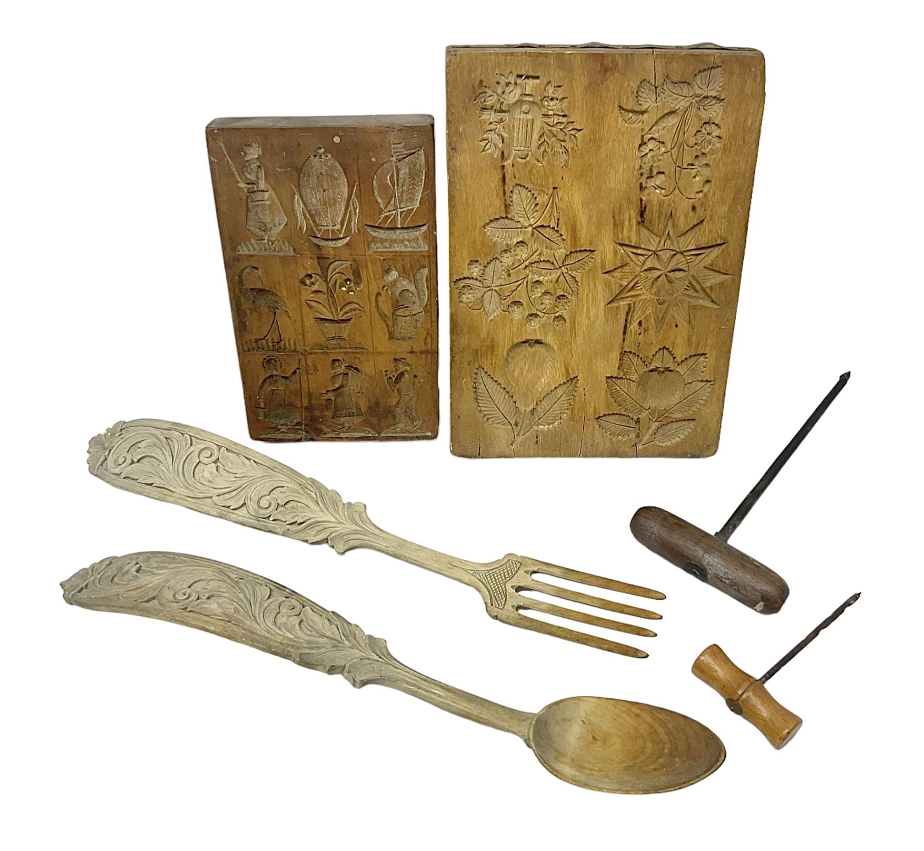 Two wooden biscuit moulds, carved loving spoon and fork, and two bradawls 