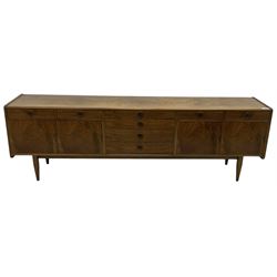 Mid-20th century figured walnut sideboard, fitted with seven drawers and two double cupboards, on tapering supports 