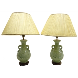  Pair 20th century Chinese Celadon baluster table lamps, decorated in relief with trailing foliage and two elephant ring moulded handles on hardwood base, H35cm excluding shade   