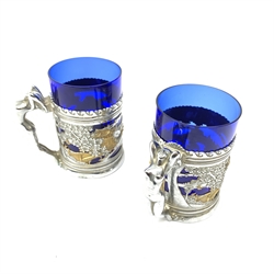  A pair of chromium plated mugs, the bodies detailed with pierced Chinoiserie bands, leading to figural handles modelled as nude female figures, with conforming pierced bases, each with blue glass liner, including glass liner H13cm.   