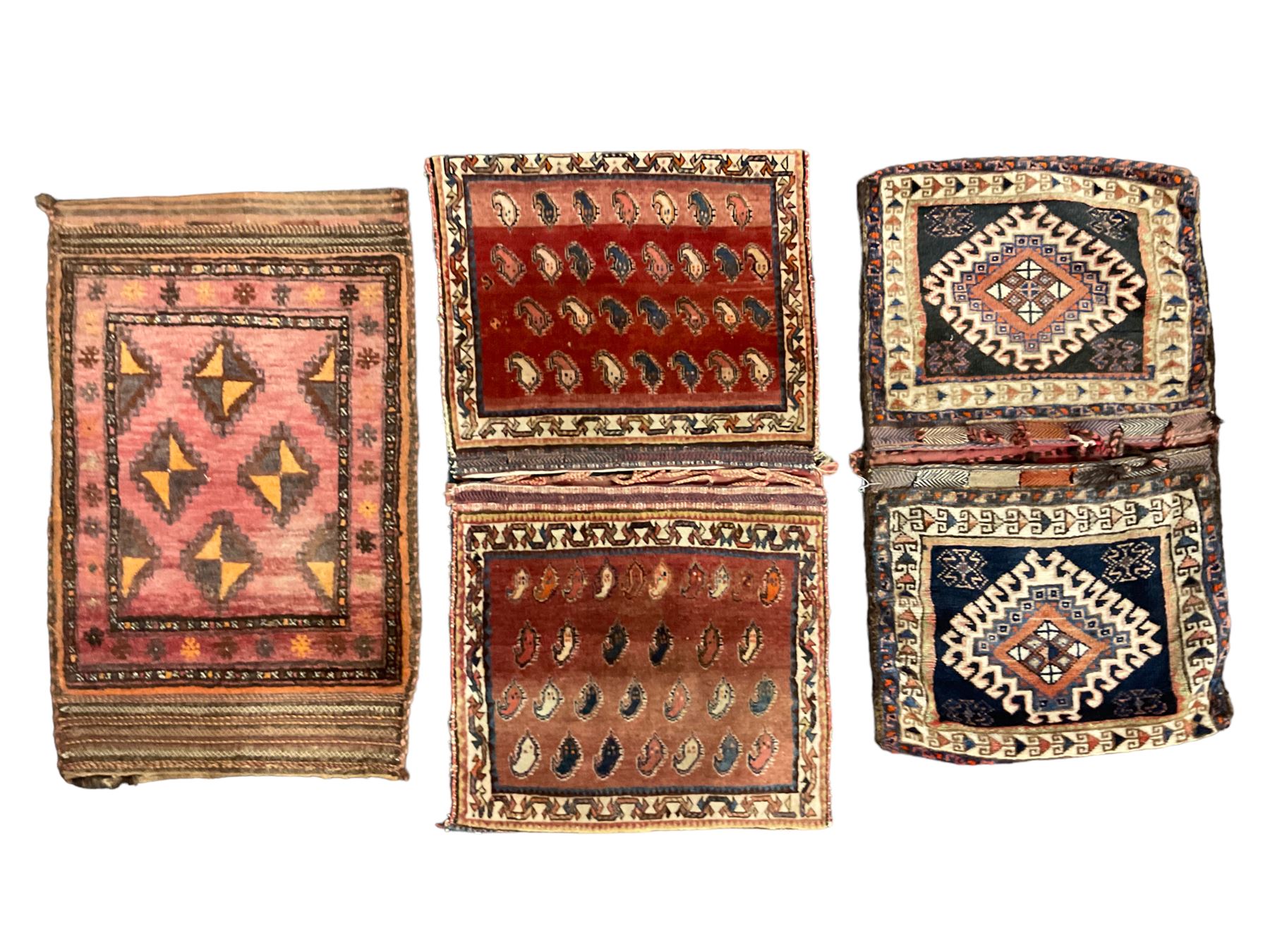 Antique Persian red ground saddle bag, decorated with all-over Boteh motifs, geometric patterned border (127cm x 68cm); Persian indigo ground saddle bag, decorated with two geometric ivory lozenges (113cm x 62cm); Persian red ground saddle bag decorated with lozenges and multi-band border (110cm x 65cm) 